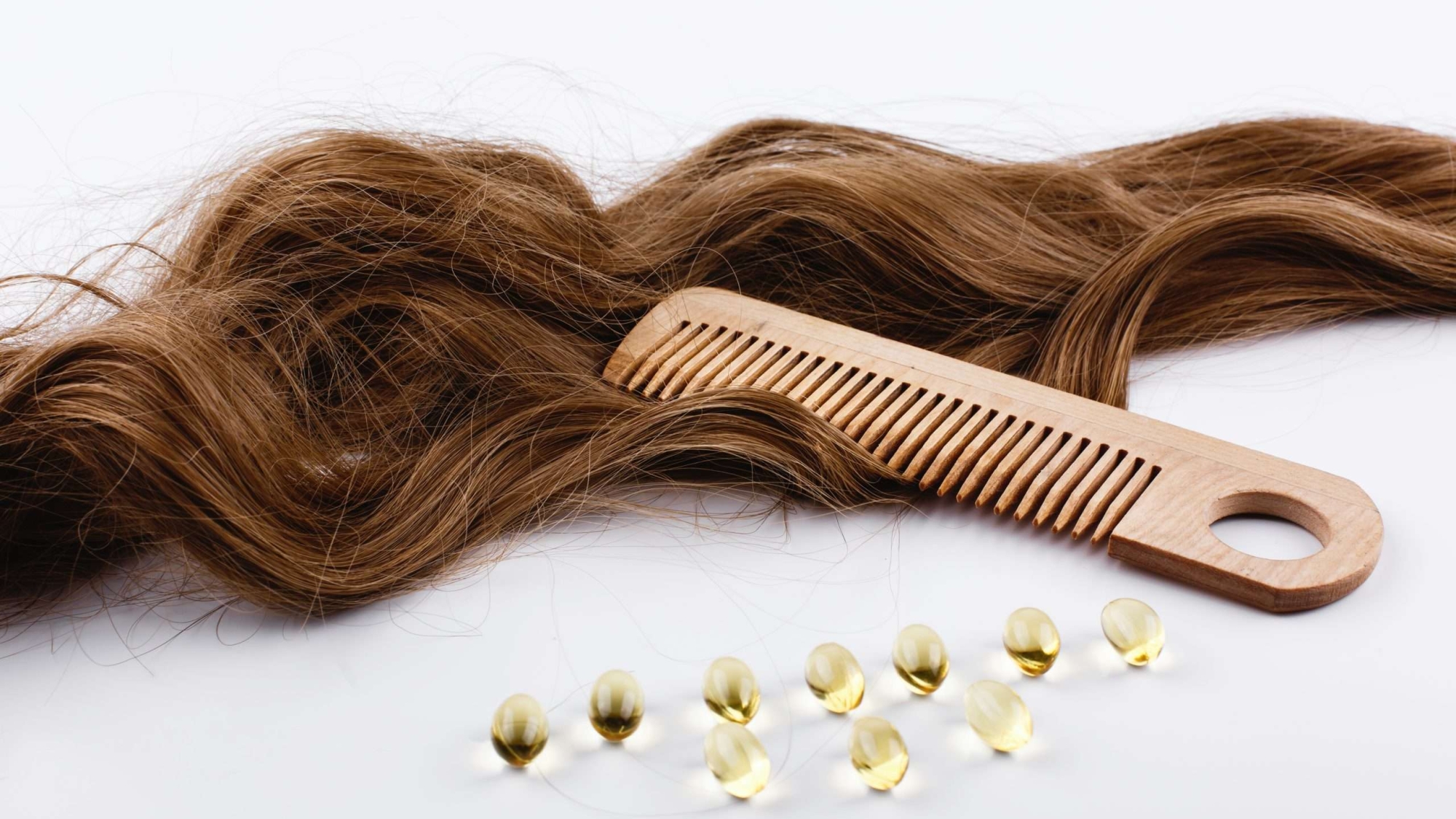 Oil capsules with viatamin E lie on brown hair curls
