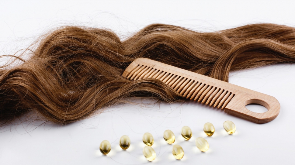 Oil capsules with viatamin E lie on brown hair curls