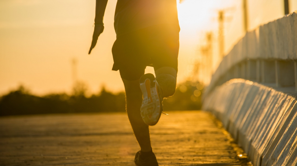 silhouette of a young fitness man running on sunrise