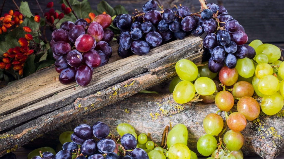 a sprig of grapes on wooden background, delicious fruit