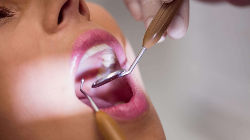 dentist-examining-female-patient-teeth