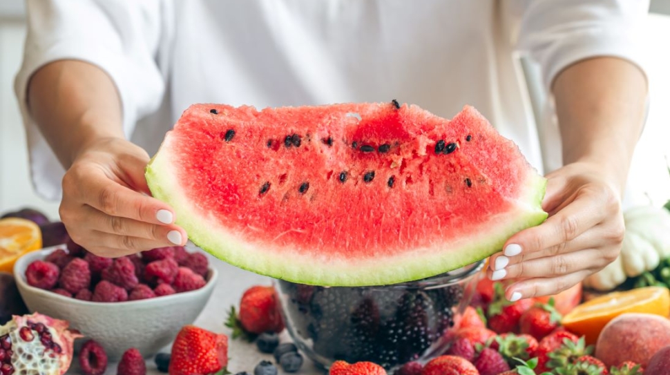 piece-watermelon-female-hands-fruits-berries-table